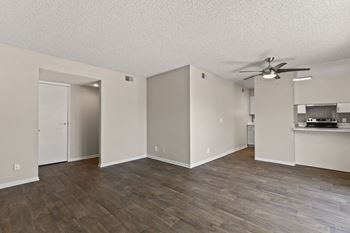 A room with a ceiling fan and wooden flooring.